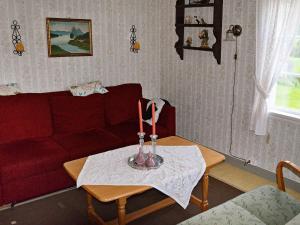 sala de estar con sofá rojo y mesa con velas en Three-Bedroom Holiday home in Gullesfjord en Flesnes