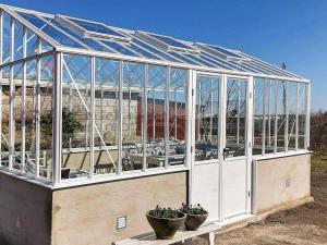 Hällevikにある5 person holiday home in S LVESBORGの鉢植えの植物が2本入ったガラス温室