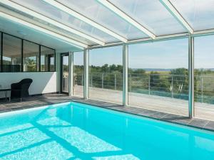 a swimming pool in a house with glass walls at Three-Bedroom Holiday home in Knebel 23 in Knebel
