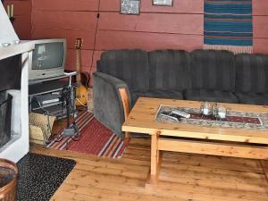 a living room with a couch and a coffee table at Holiday Home Hjalmarhytta in Søre Birkedal