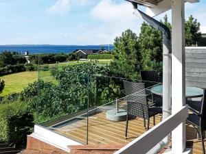 a balcony with a table and a view of the ocean at 8 person holiday home in Ebeltoft in Ebeltoft