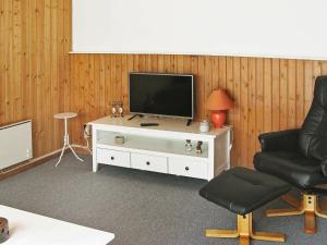 Nørre Vorupørにある4 person holiday home in Thistedのリビングルーム(テレビ、椅子付)