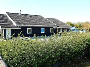 una casa negra con muchas plantas delante de ella en 12 person holiday home in Nordborg, en Nordborg