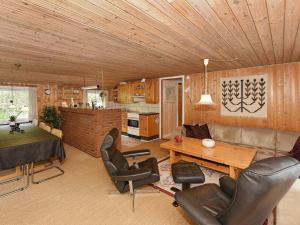 a living room with a table and chairs and a kitchen at 8 person holiday home in N rre Nebel in Lønne Hede