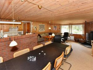 a living room with a large black table and chairs at 8 person holiday home in N rre Nebel in Lønne Hede