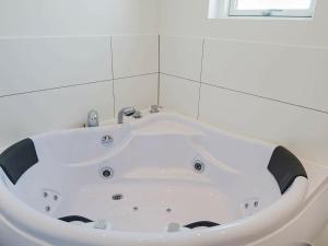 a white bath tub in a bathroom with a window at 14 person holiday home in Glesborg in Glesborg