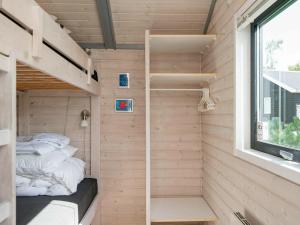 KnebelにあるThree-Bedroom Holiday home in Knebel 22の小さな家 二段ベッド2組、窓付