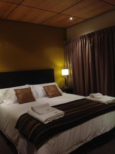 Un pat sau paturi într-o cameră la Maria del Bosque Apart Hotel / Cabañas