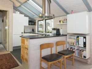 a kitchen with two chairs and a counter with a sink at Seaside Bliss in Aarhus - By Traum Ferienwohnungen in Knebel +14 photos