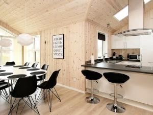 cocina y comedor con mesa y sillas en Four-Bedroom Holiday home in Løkken 26, en Løkken