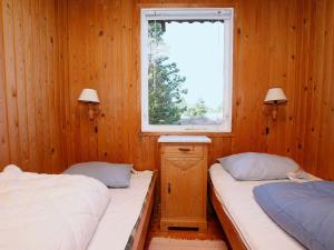 Ålbækにある4 person holiday home in lb kのウッドルーム ベッド2台 窓付