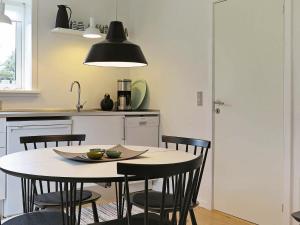 a kitchen with a table with chairs and aendant light at 5 person holiday home in Harbo re in Harboør