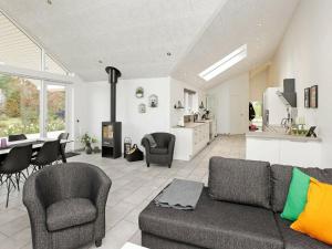 GørlevにあるTwo-Bedroom Holiday home in Tomrefjordのリビングルーム(ソファ、椅子付)、キッチンが備わります。