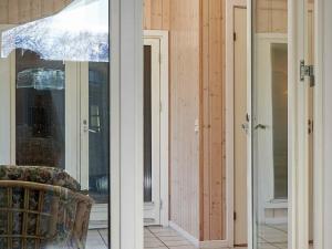 a room with two sliding glass doors and a chair at 12 person holiday home in Aakirkeby in Vester Sømarken