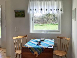 a dining room table with two chairs and a window at 3 person holiday home in FJ LKINGE in Fjälkinge