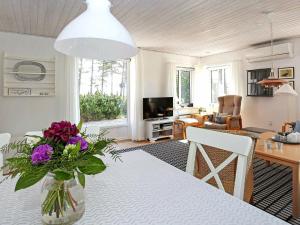 a living room with a table with a vase of flowers at 5 person holiday home in R m in Rømø Kirkeby