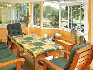 ein Esszimmer mit einem Tisch, Stühlen und Fenstern in der Unterkunft One-Bedroom Holiday home in Hästveda in Lur