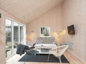 ロンストラップにある9 person holiday home in Hj rringのリビングルーム(椅子、テーブル、テレビ付)
