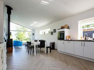 a kitchen with white cabinets and a table with chairs at 7 person holiday home in Jægerspris-By Traum in Jægerspris