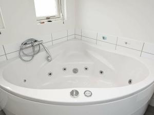 a white bath tub in a bathroom with a window at 8 person holiday home in R m in Bolilmark