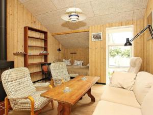 スケーエンにある6 person holiday home in Skagenのリビングルーム(木製テーブル、椅子付)