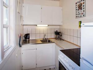 4 person holiday home in Hemmet في Hemmet: مطبخ مع دواليب بيضاء ومغسلة