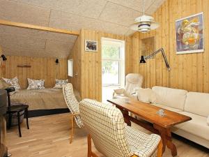 スケーエンにある6 person holiday home in Skagenのリビングルーム(ソファ、テーブル、ベッド付)