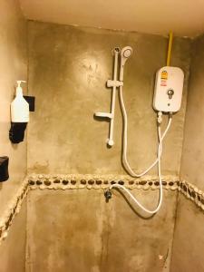 een douche in een vuile badkamer met een slang bij Green Home in Khao Lak