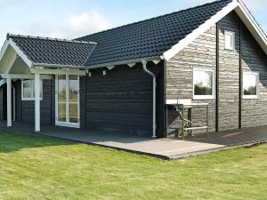 uma casa preta com um alpendre e um deque em 10 person holiday home in Sydals em Vibøge