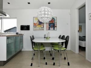 6 person holiday home in Hadsund في Øster Hurup: مطبخ وغرفة طعام مع طاولة وكراسي