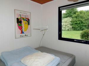 a small bedroom with a bed and a window at 6 person holiday home in B rkop in Egeskov