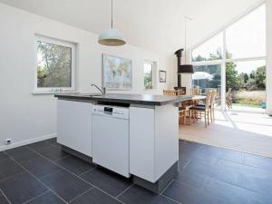 a white kitchen with a counter and a dining room at 6 person holiday home in Nykøbing Sj-By Traum in Tjørneholm