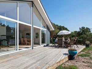 a group of people sitting at a table on a wooden deck at 6 person holiday home in Nykøbing Sj-By Traum in Tjørneholm
