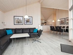 グローセンブローデにある10 person holiday home in Gro enbrodeのリビングルーム(ソファ、テーブル、椅子付)