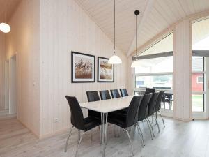 a dining room with a table and black chairs at 10 person holiday home in Gro enbrode in Großenbrode