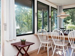 a dining room with a table and chairs and windows at 4 person holiday home in Silkeborg in Silkeborg