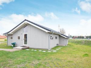 a small white house with a grassy yard at 8 person holiday home in Gro enbrode in Großenbrode