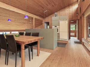 a kitchen and dining room with a wooden table and chairs at 8 person holiday home in Asn s in Asnæs