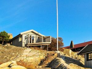 a house on top of a hill with a flag pole at 2 person holiday home in TORSLANDA in Hällsvik