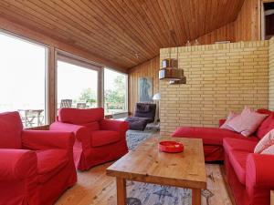 a living room with red couches and a wooden ceiling at 8 person holiday home in Asn s in Asnæs