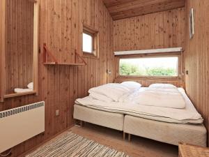 a bedroom with a bed in a wooden wall at 8 person holiday home in Asn s in Asnæs