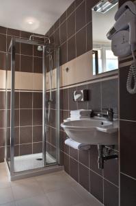 uma casa de banho com um lavatório e um chuveiro em Hôtel de la Motte Picquet em Paris