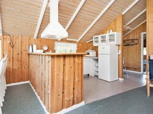 eine Küche mit Holzwänden und einem weißen Kühlschrank in der Unterkunft 7 person holiday home in Bl vand in Ho