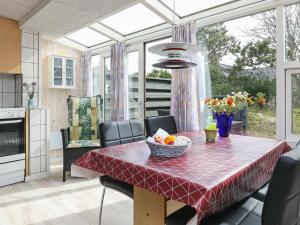 a kitchen with a table with a bowl of fruit on it at 4 person holiday home in Vejers Strand in Vejers Strand