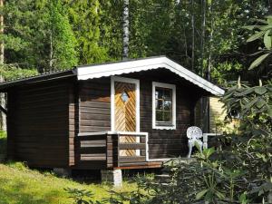 a small wooden cabin with a porch and a door at 5 person holiday home in KIL in Kil