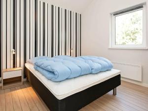 TjørneholmにあるHoliday home Øster Asselsのベッド(上に青い枕付)