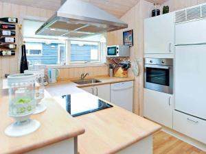 a kitchen with white appliances and a counter top at Lakeview Retreat in Dagelokke - By Traum Ferienwohnungen in Tranekær +13 photos