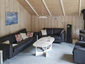 ein Wohnzimmer mit einem Sofa und einem Tisch in der Unterkunft 6 person holiday home in Oksb l in Oksbøl