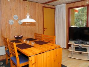 ブラーバンドにある6 person holiday home in Bl vandのダイニングルーム(木製テーブル、テレビ付)