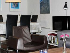 a living room with chairs and a table and a television at Holiday Home Fyrvej VII in Blåvand